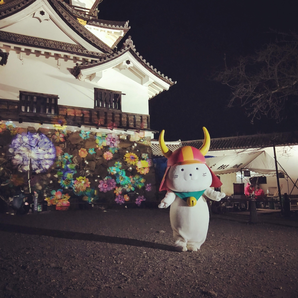 彦根城夜間特別公開の花アートNAKED GARDEN ONE KYOTOの前でポーズを決めるひこにゃん