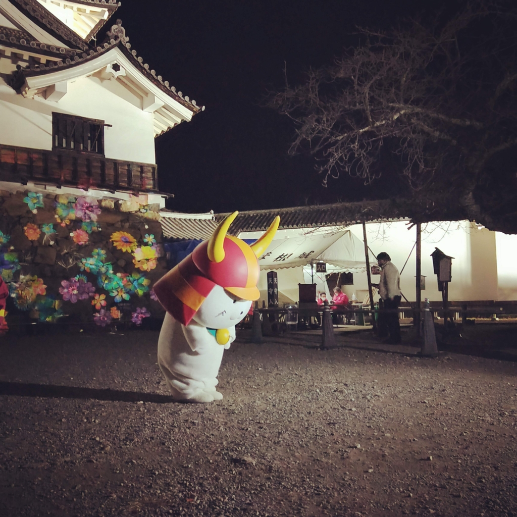 彦根城夜間特別公開の花アートNAKED GARDEN ONE KYOTOの前でポーズを決めるひこにゃん